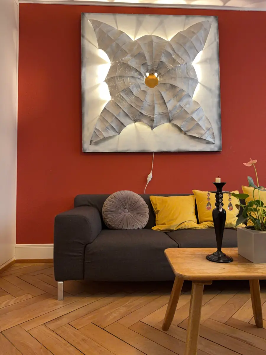 Praxisraum in der Steinberggasse in der Winterthurer Altstadt: rote Wand mit Lichtbild, Sofa und Holztisch